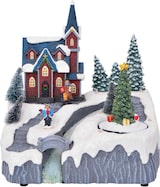 Ein weihnachtliches Dorf mit einer Kirche und Bäumen.