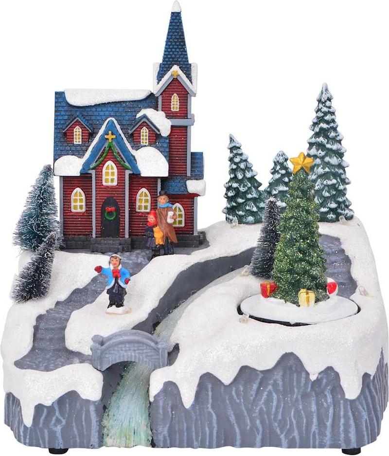Ein weihnachtliches Dorf mit einer Kirche und Bäumen.