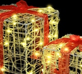 Beleuchtete Geschenke mit roten Schleifen.