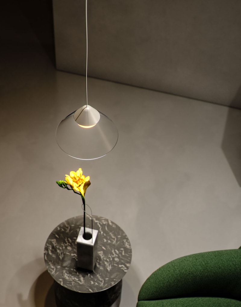 Eine Lampe hängt über einer Blume in einer Vase.