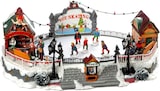 Eine beleuchtete Eisbahn mit Figuren und Gebäuden.