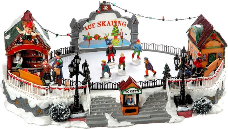 Eine beleuchtete Eisbahn mit Figuren und Gebäuden.