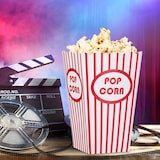 Ein Behälter mit Popcorn und Filmrequisiten.