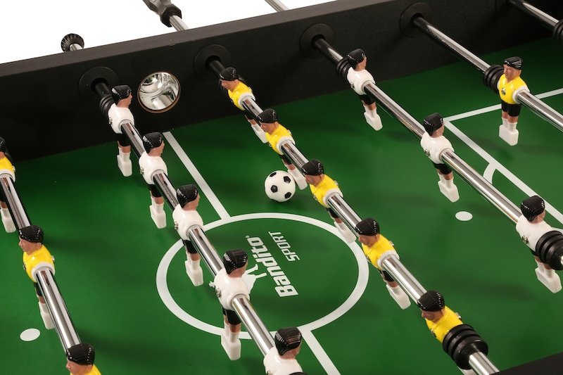 Ein Tischfußballspiel mit gelben und weißen Spielern.