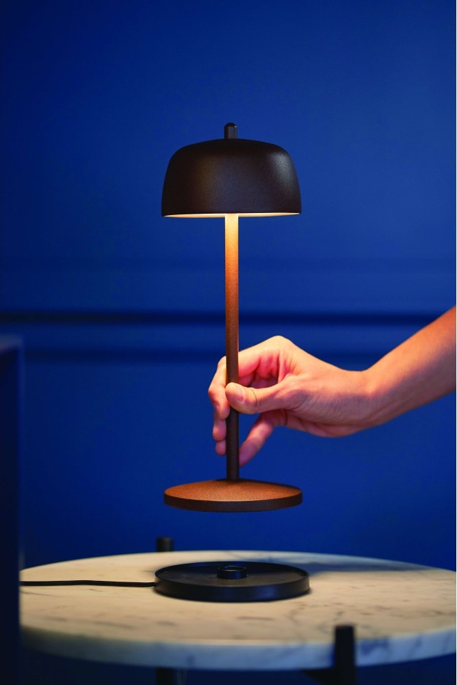 Eine Hand hält eine schwimmende Lampe.