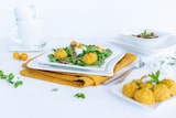 Een bord met balletjes en salade.