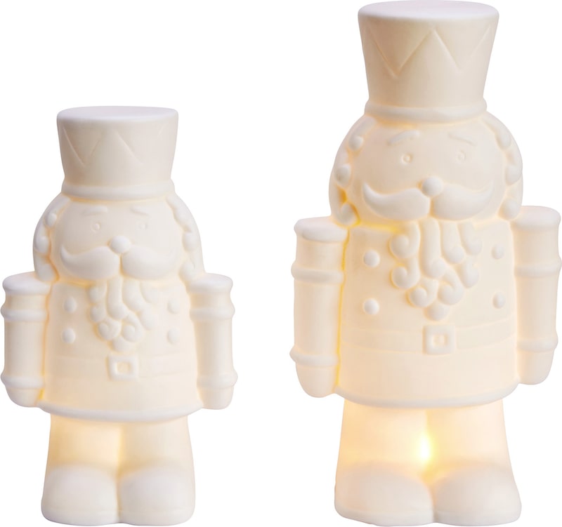Zwei weiße Nussknacker-Figuren mit Lichtern.
