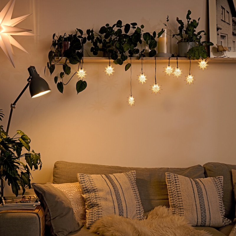 Sterne-Lichterkette über einem Sofa.