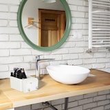 Ein Behälter mit Make-up-Pinseln auf einem Waschbecken.