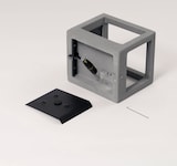 Un cubo gris con soporte negro y herramienta.