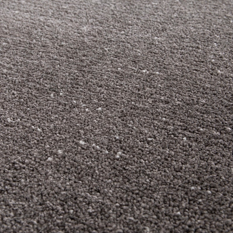 Una alfombra gris con pequeñas fibras blancas.