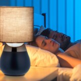 Ein Nachttisch mit einer Lampe und schlafenden Personen.