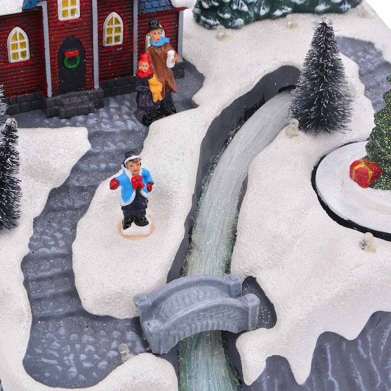Eine Miniatur-Weihnachtslandschaft mit Figuren und Bäumen.