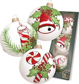 Weiße Glasornamente mit Weihnachtsmotiven.