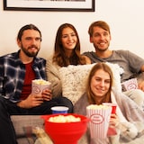 Vier Leute schauen einen Film mit Popcorn.