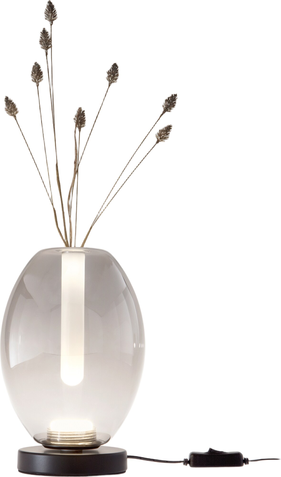 Eine Vase mit einem Licht und Zweigen.