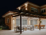 Un patio cubierto con muebles e iluminación.