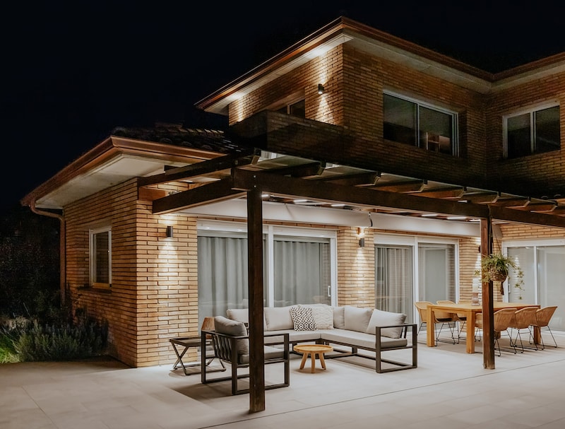 Un patio cubierto con muebles e iluminación.