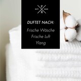 Ein Stapel weißer Handtücher mit Baumwollzweigen.