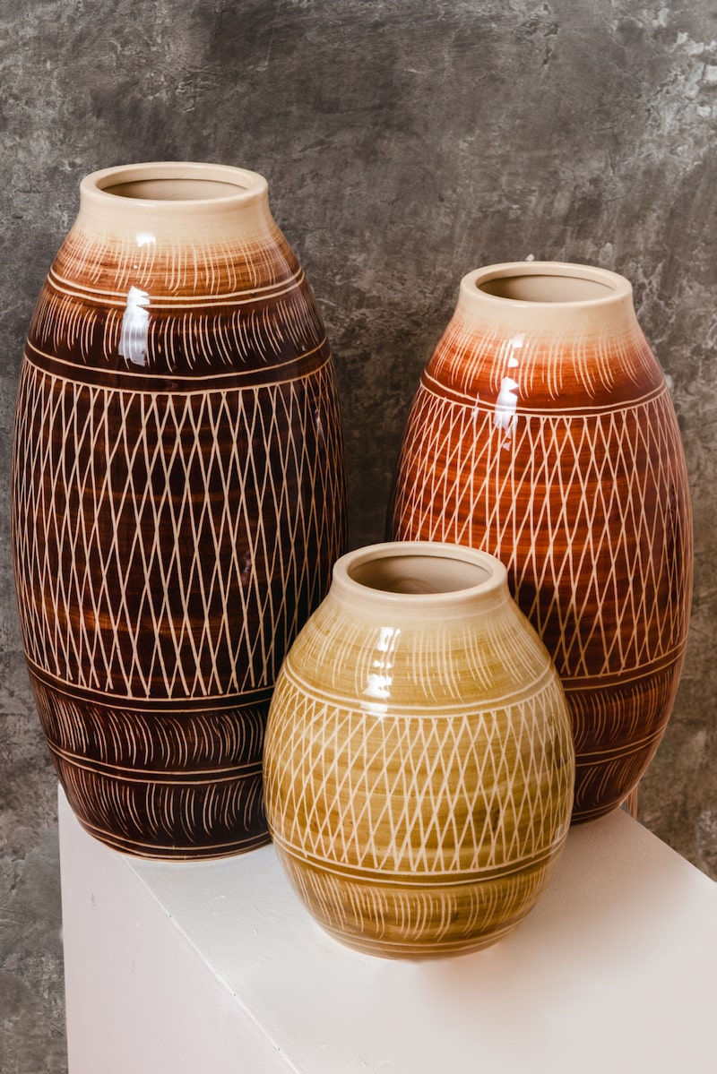 Drei braune und beige Vasen mit Muster.