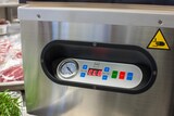 Una macchina sottovuoto con manometro e controlli.