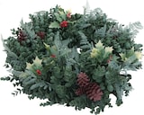 Ein Kranz aus grünen Blättern mit Zapfen und Beeren.