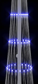 Ein weißer Mast mit blauen Lichtern.