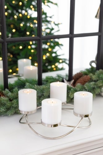 Ein Adventskranz mit vier weißen Kerzen.