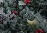 Ein künstlicher Weihnachtskranz mit Beeren und Tannenzapfen.