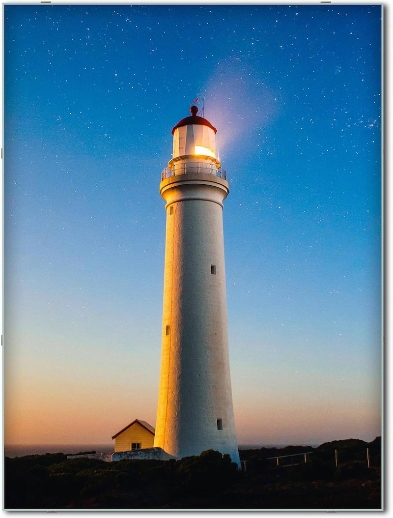 Un faro al atardecer con estrellas.