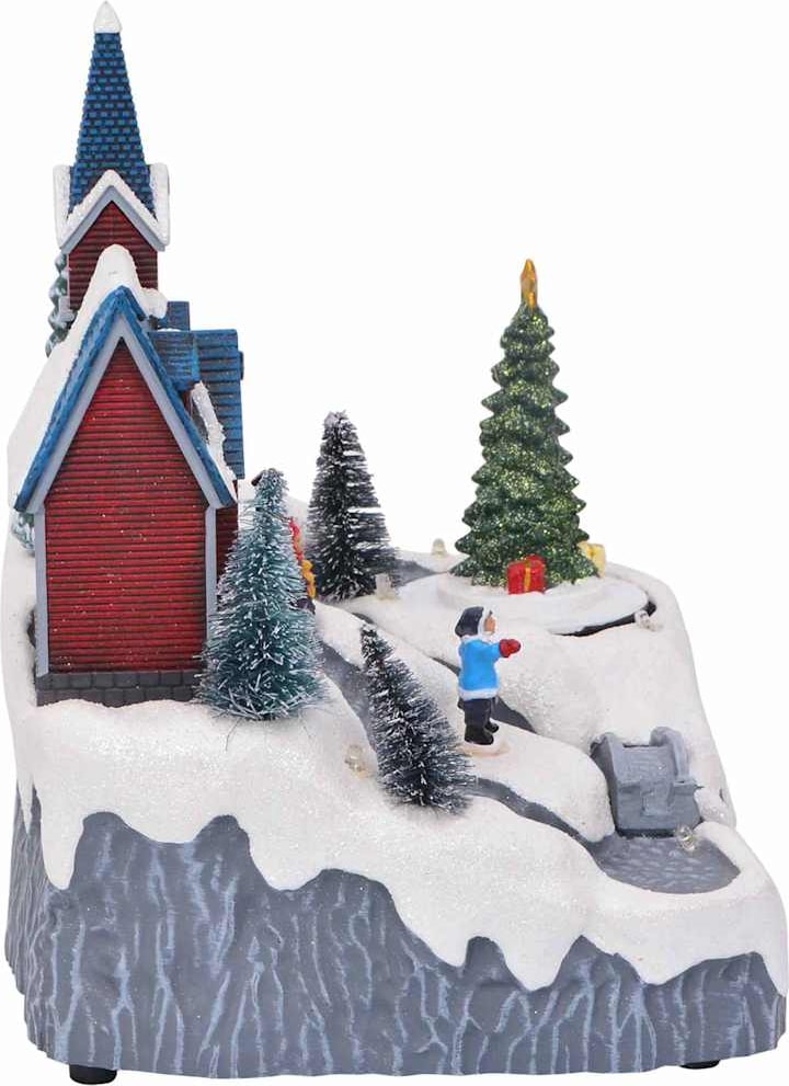 Ein weihnachtliches Dorf mit einer Kirche und einem Baum.