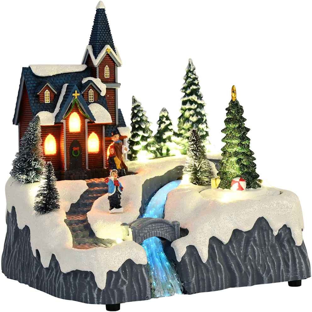 Beleuchtetes Weihnachtsdorf mit Wasserfall und Kirche.