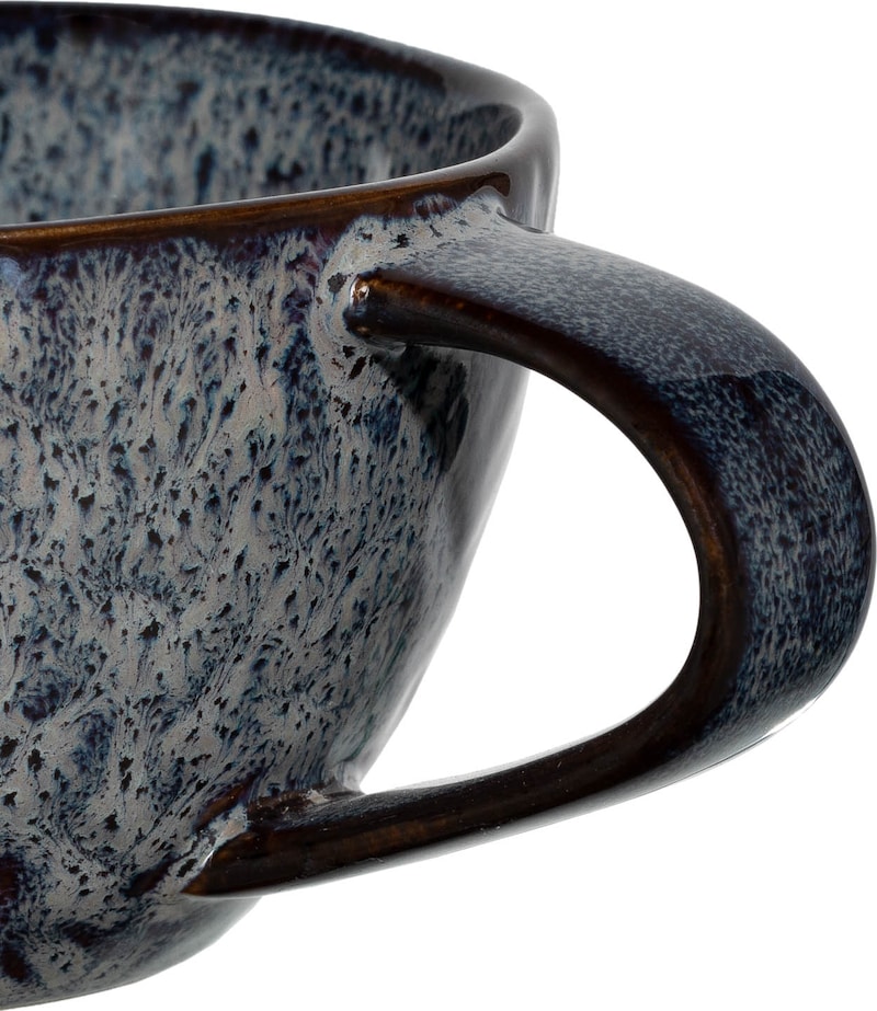 Eine Nahaufnahme einer Tasse mit einem Griff.
