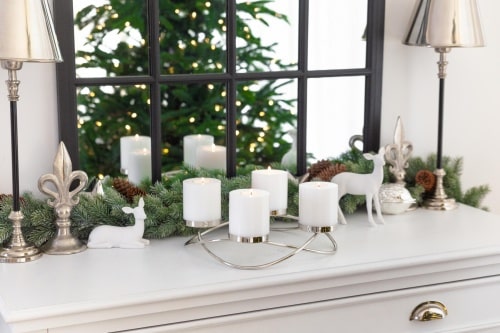 Ein Kerzenständer mit vier Kerzen und Hirschfiguren.