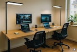 Zwei moderne Schreibtische mit Computern und Lampen.