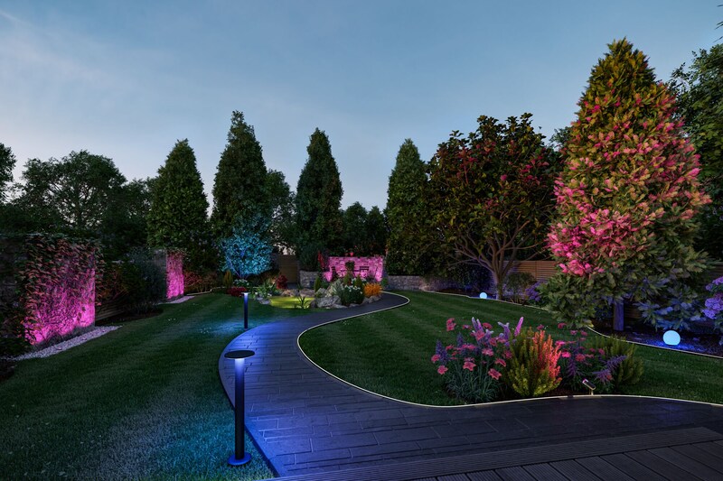 Ein beleuchteter Gartenweg mit bunten Lichtern.