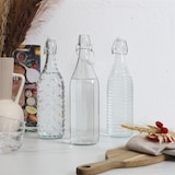 thumbnail of Garrafa de vidro com tampa basculante de 1 litro – Vidro transparente com padrão de bolhas – Transparente