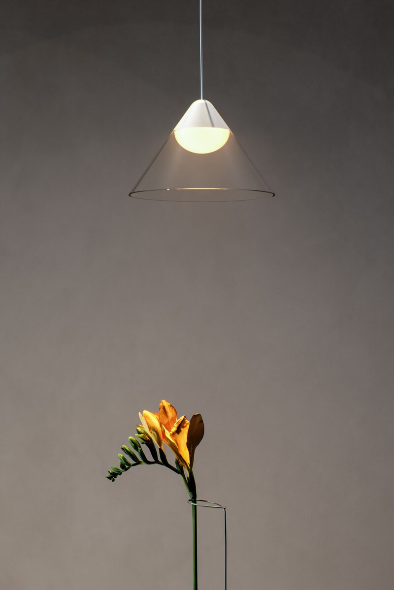 Eine Lampe über einer Blume in einer Vase.