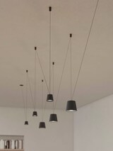 Mehrere dunkle Pendelleuchten hängen von der Decke.