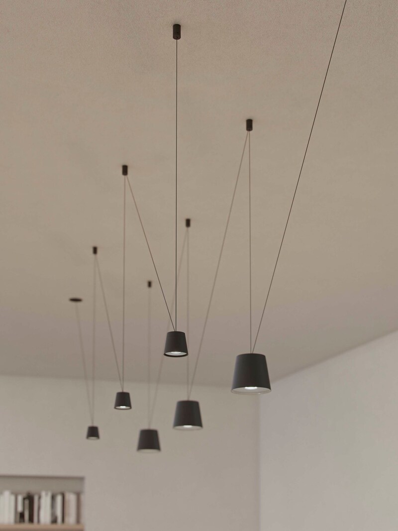 Mehrere dunkle Pendelleuchten hängen von der Decke.