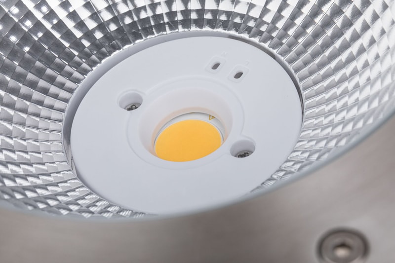 Une base ronde et blanche avec une seule LED jaune.