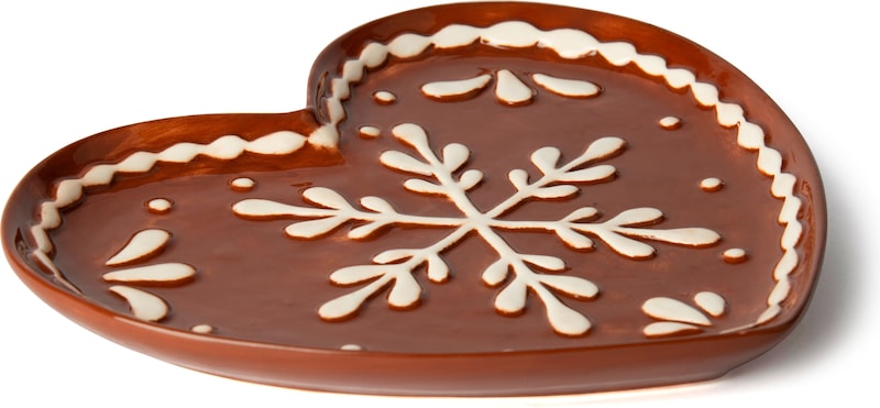Ein brauner, herzförmiger Teller mit Schneeflocke.
