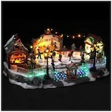 Eine beleuchtete Weihnachtsdorf-Eislaufszene.