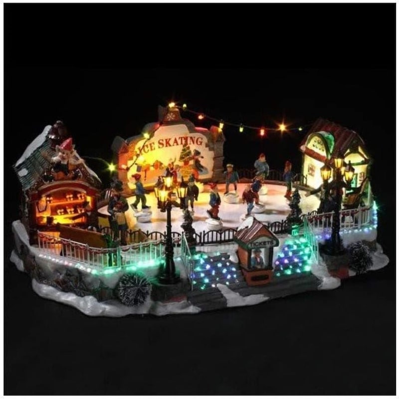 Eine beleuchtete Weihnachtsdorf-Eislaufszene.