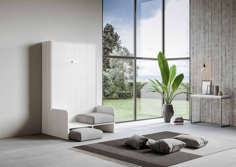 Ein weißes Bett mit Sitzgelegenheit und Hocker.