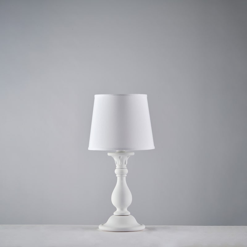 Eine weiße Lampe mit einem Lampenschirm.