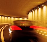 Ein Auto fährt durch einen beleuchteten Tunnel.