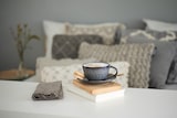 Eine Tasse Kaffee steht auf Büchern.