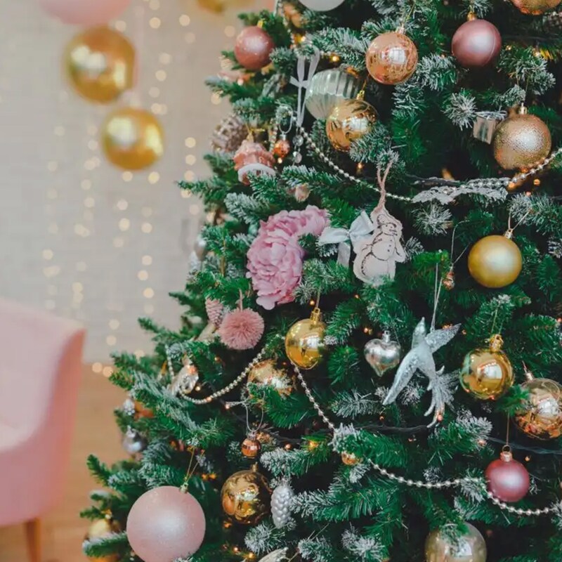 Ein geschmückter Weihnachtsbaum mit rosa und goldenen Kugeln.