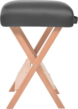 Ein tragbarer Hocker mit Holzbeinen und schwarzem Sitz.